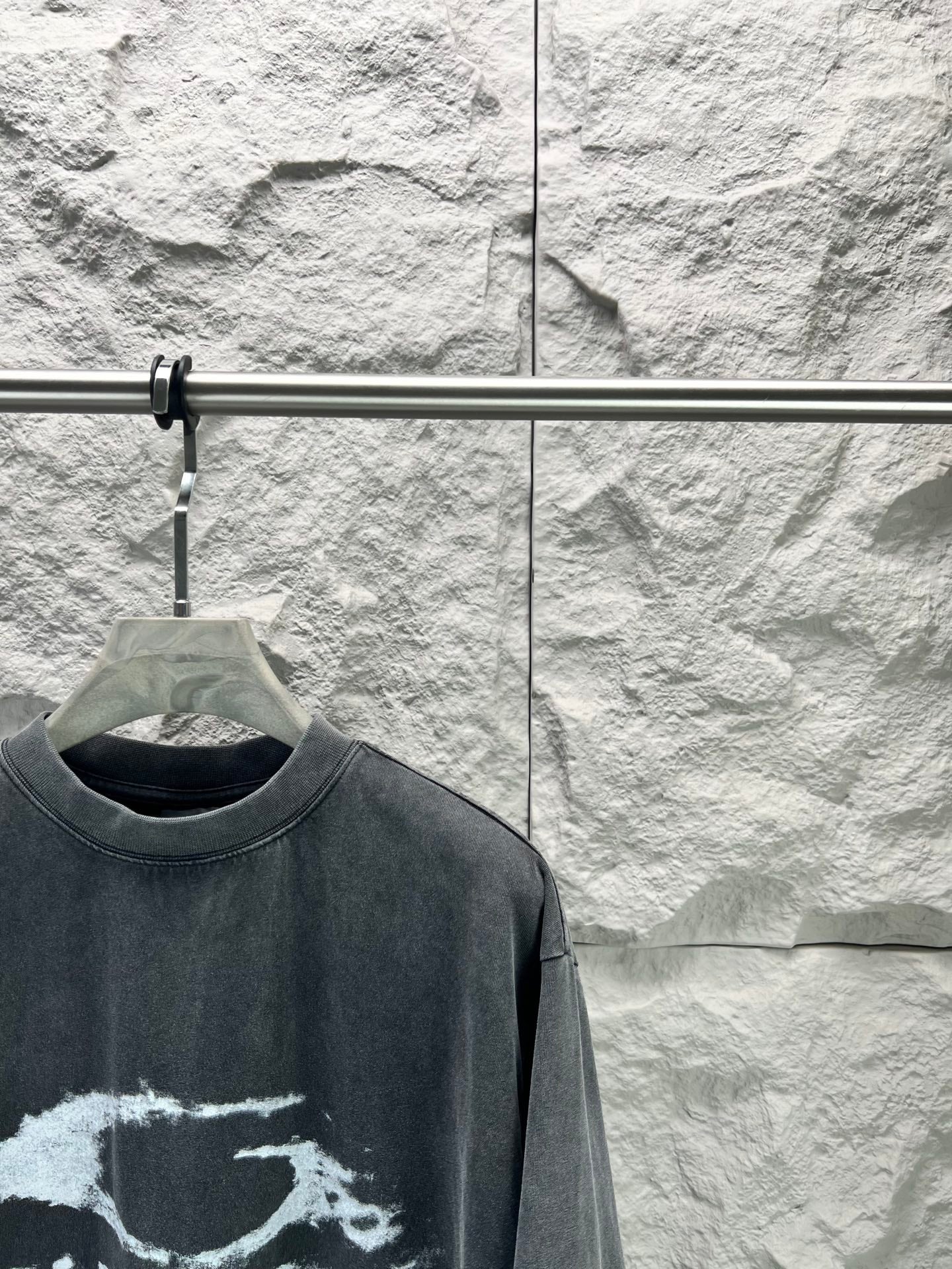 Dark short-sleeve T-shirt close-up of crew neck and partial distressed logo