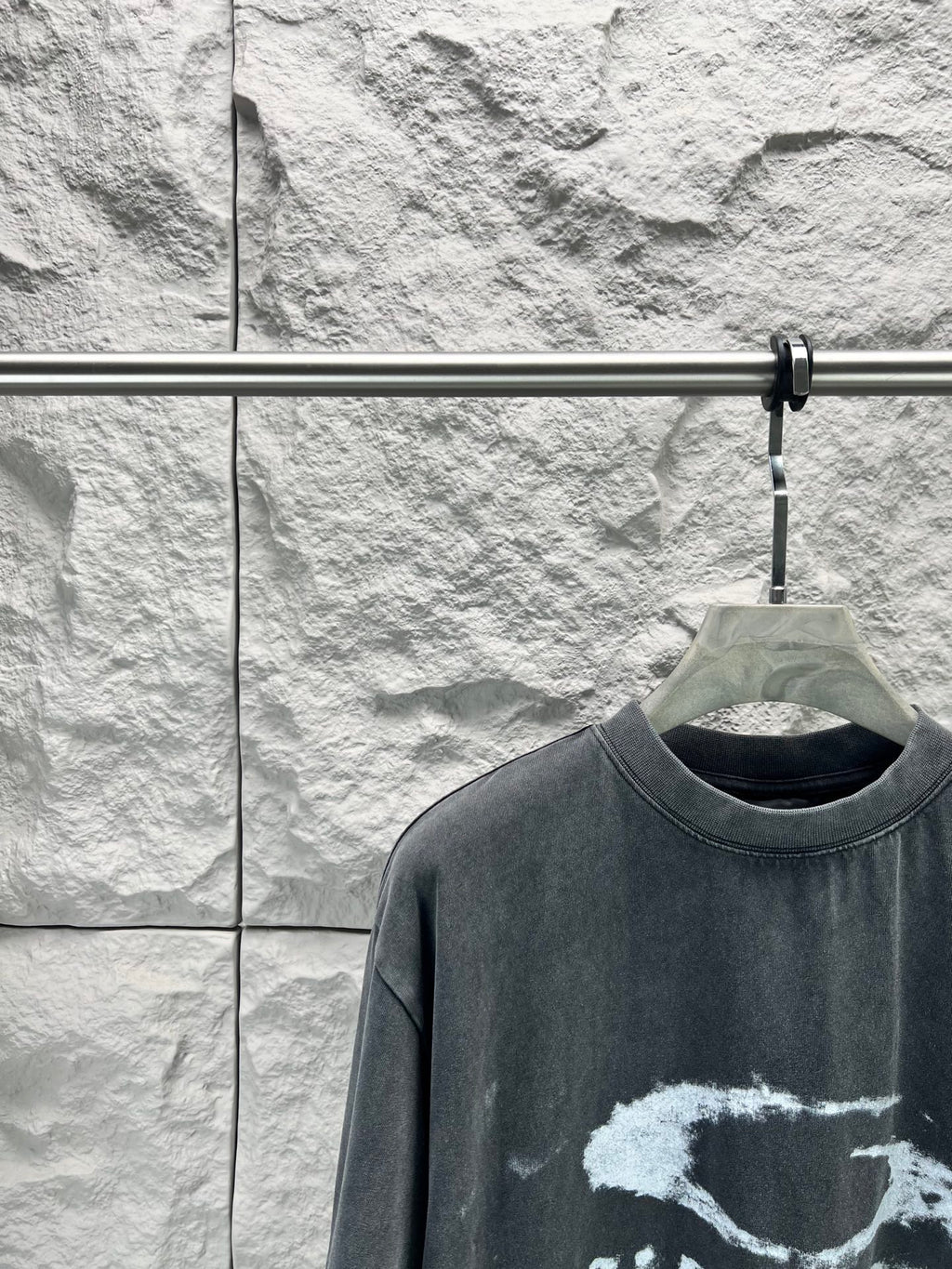 Dark short-sleeve T-shirt close-up of crew neck and distressed logo graphic