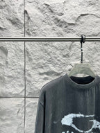 Dark short-sleeve T-shirt close-up of crew neck and distressed logo graphic