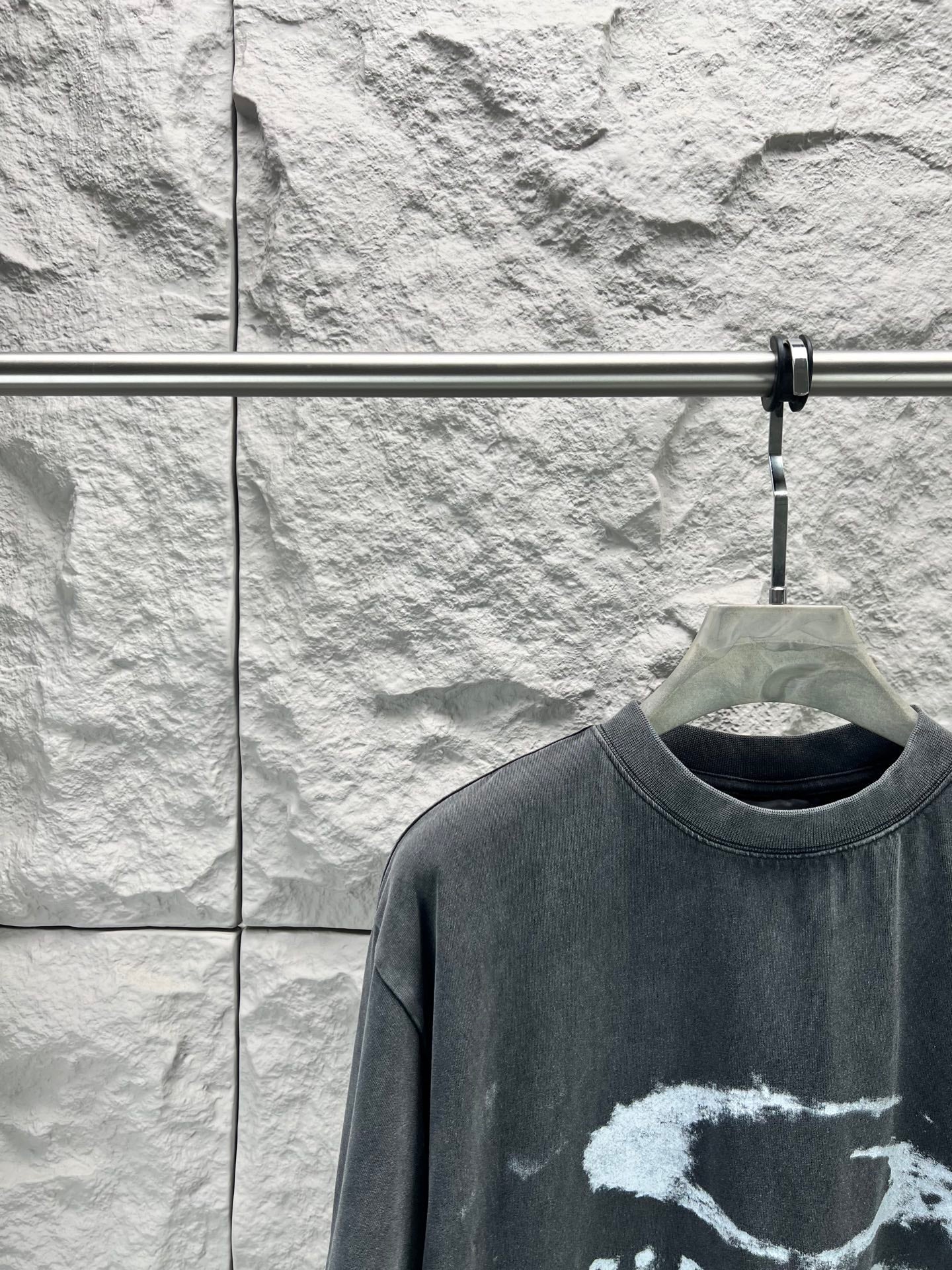Dark short-sleeve T-shirt close-up of crew neck and distressed logo graphic
