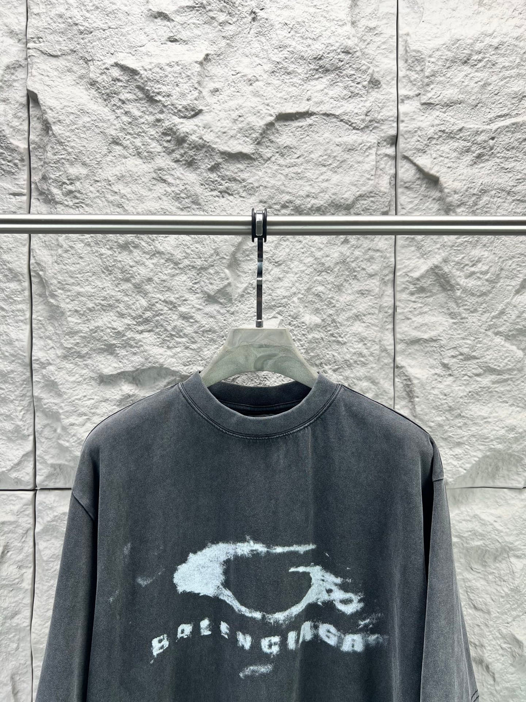 Dark short-sleeve T-shirt with distressed oval logo and text print across chest