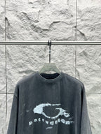 Dark short-sleeve T-shirt with distressed oval logo and text print across chest