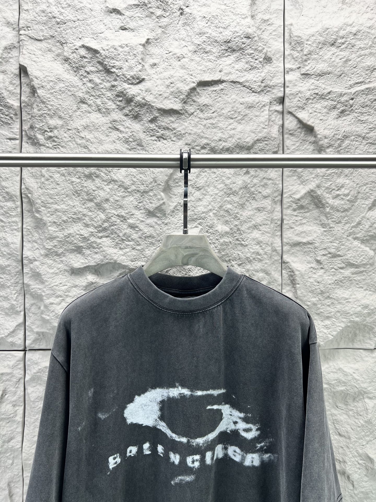 Dark short-sleeve T-shirt with distressed oval logo and text print across chest