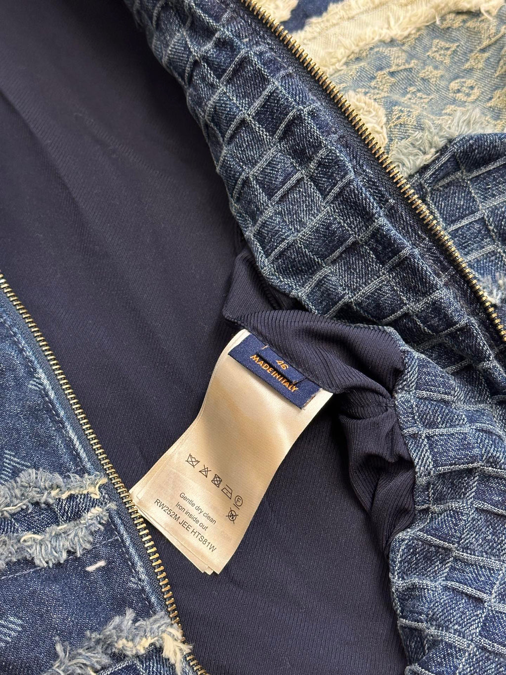Denim jacket interior label and zipper edge, blue textured lining and seam details