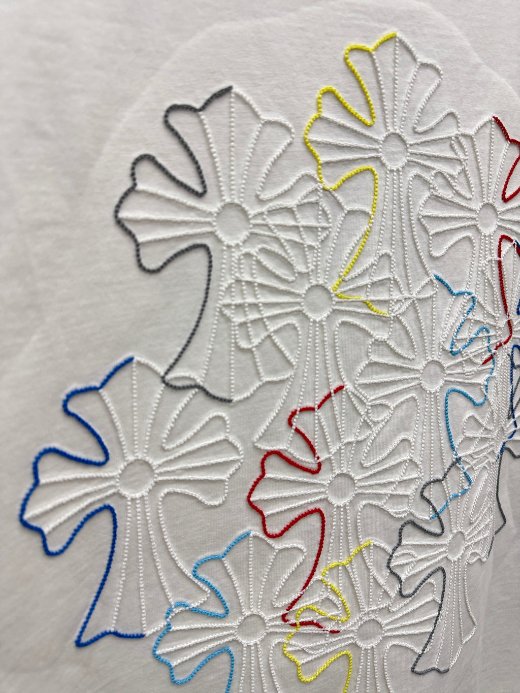 Close-up of white T-shirt fabric with multicolor floral embroidery