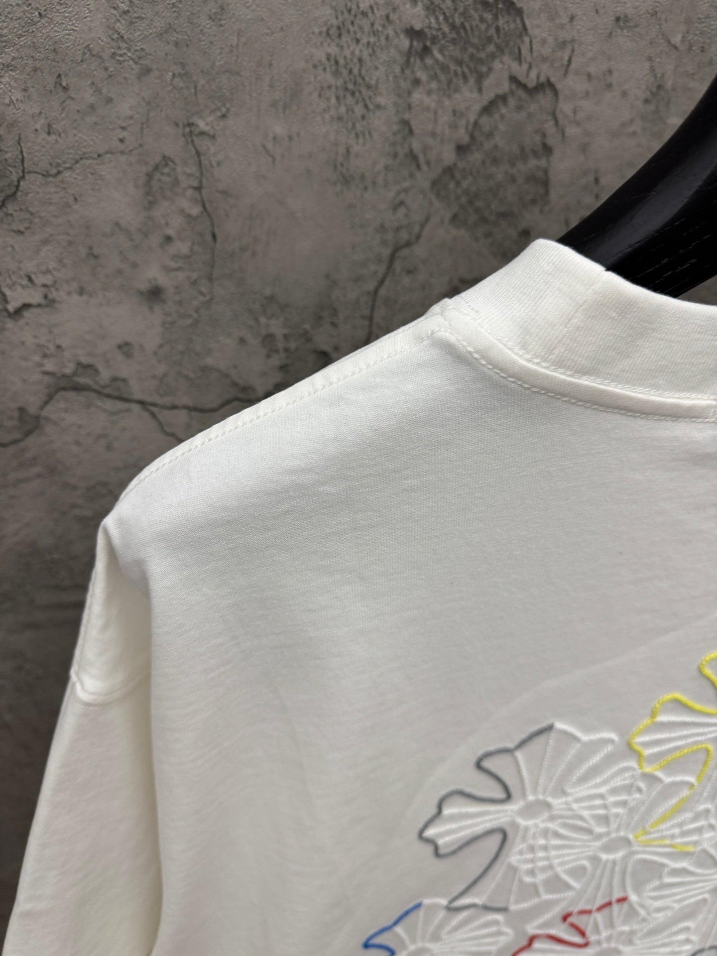 White T-shirt shoulder and upper back with partial multicolor floral embroidery