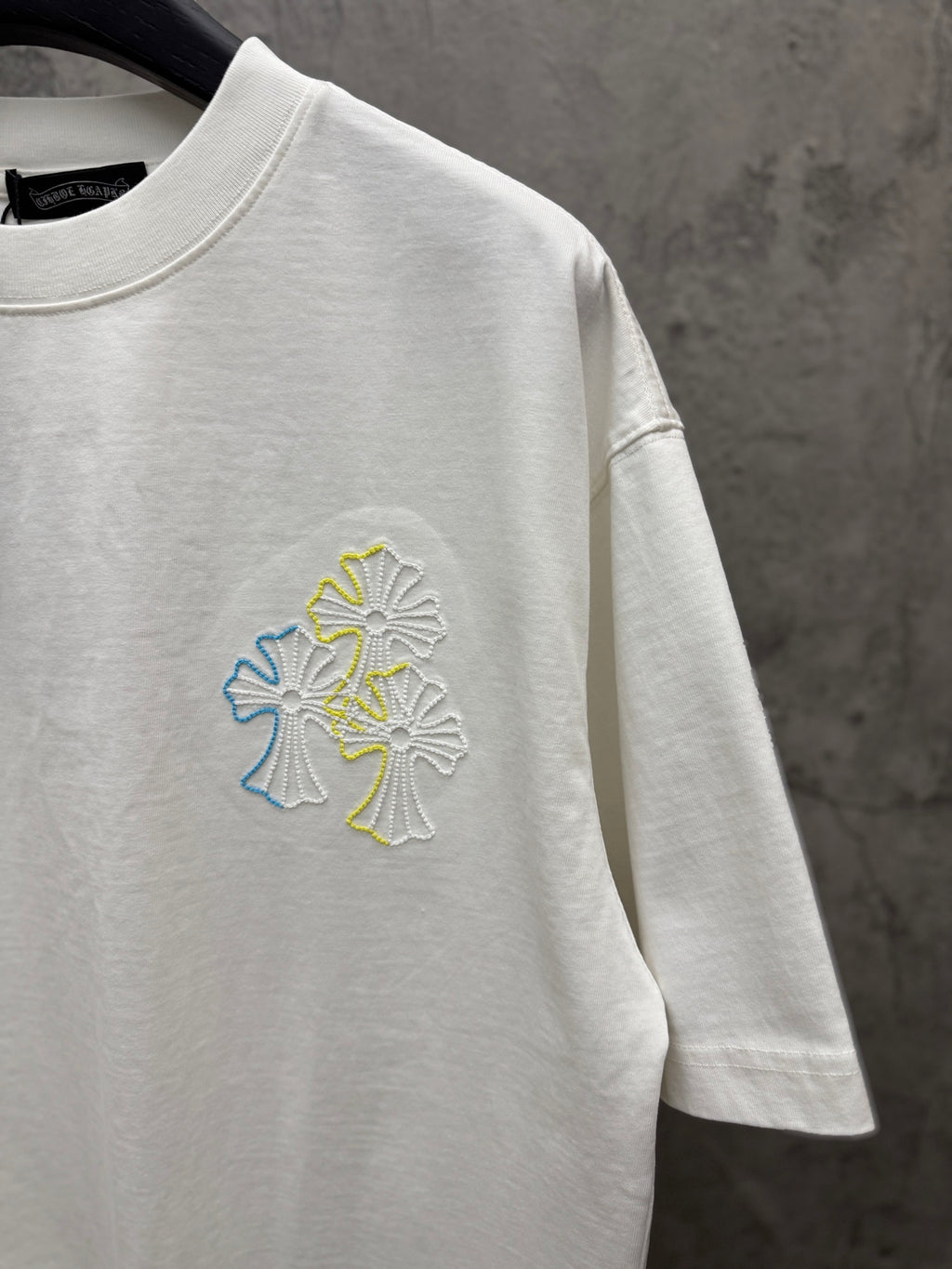White short-sleeve T-shirt with small multicolor floral embroidery on chest