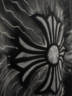 Black T-shirt close-up of stylized sunburst flower graphic with lightning lines