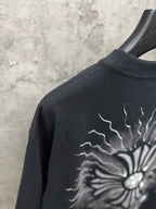 Black T-shirt close-up of back sunburst graphic with lightning-style rays