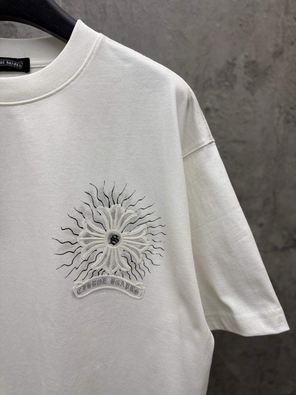White short-sleeve T-shirt chest sunburst floral graphic close-up