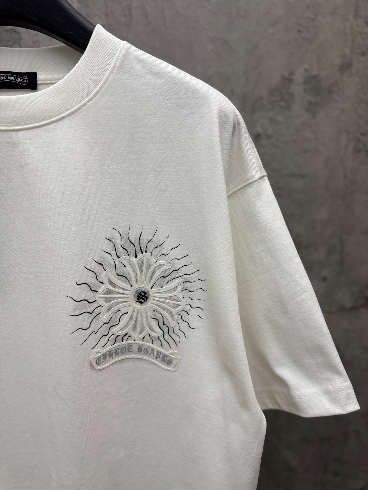 White short-sleeve T-shirt chest sunburst floral graphic close-up