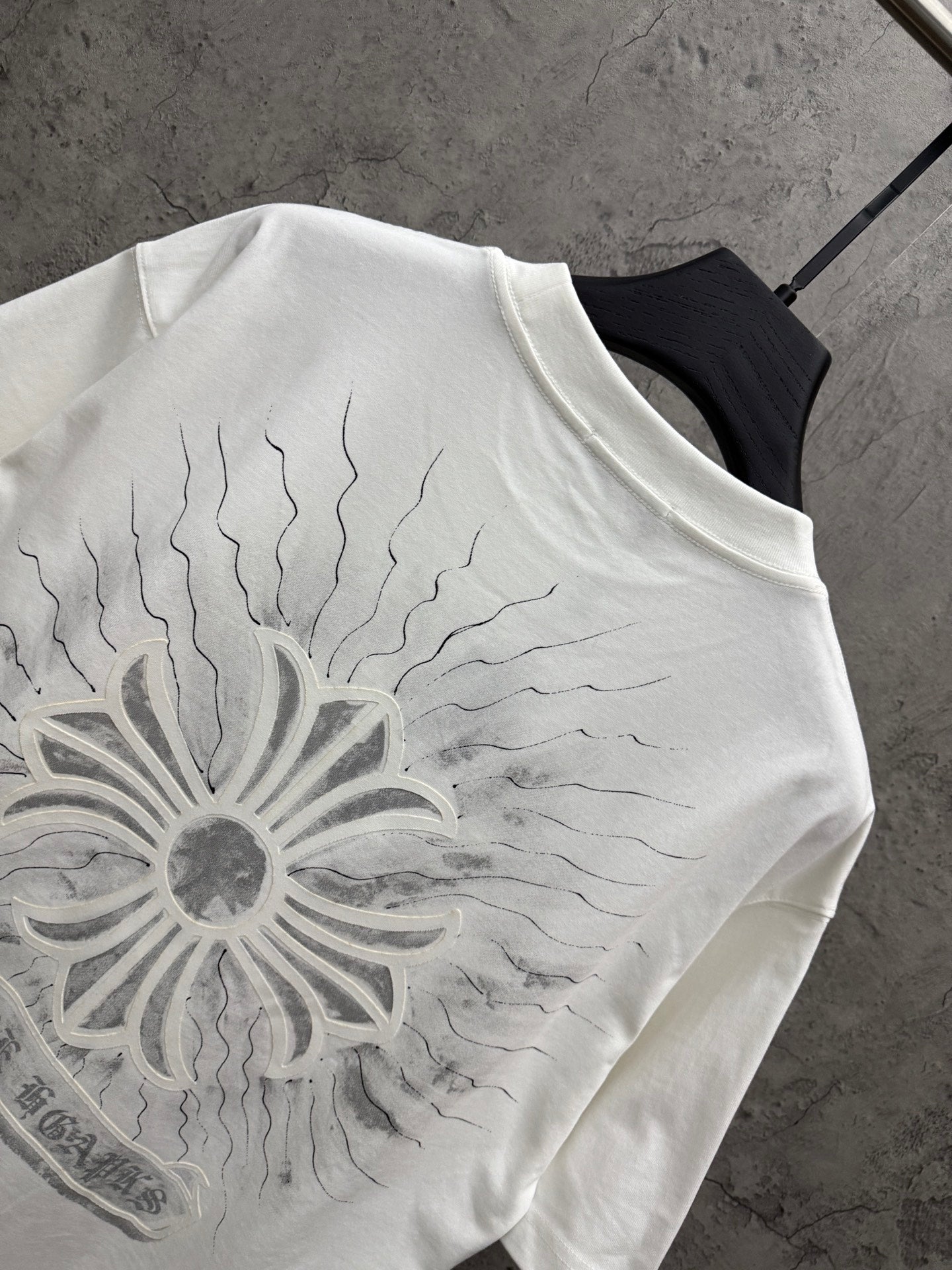 White short-sleeve T-shirt close-up of large sunburst floral graphic on the back