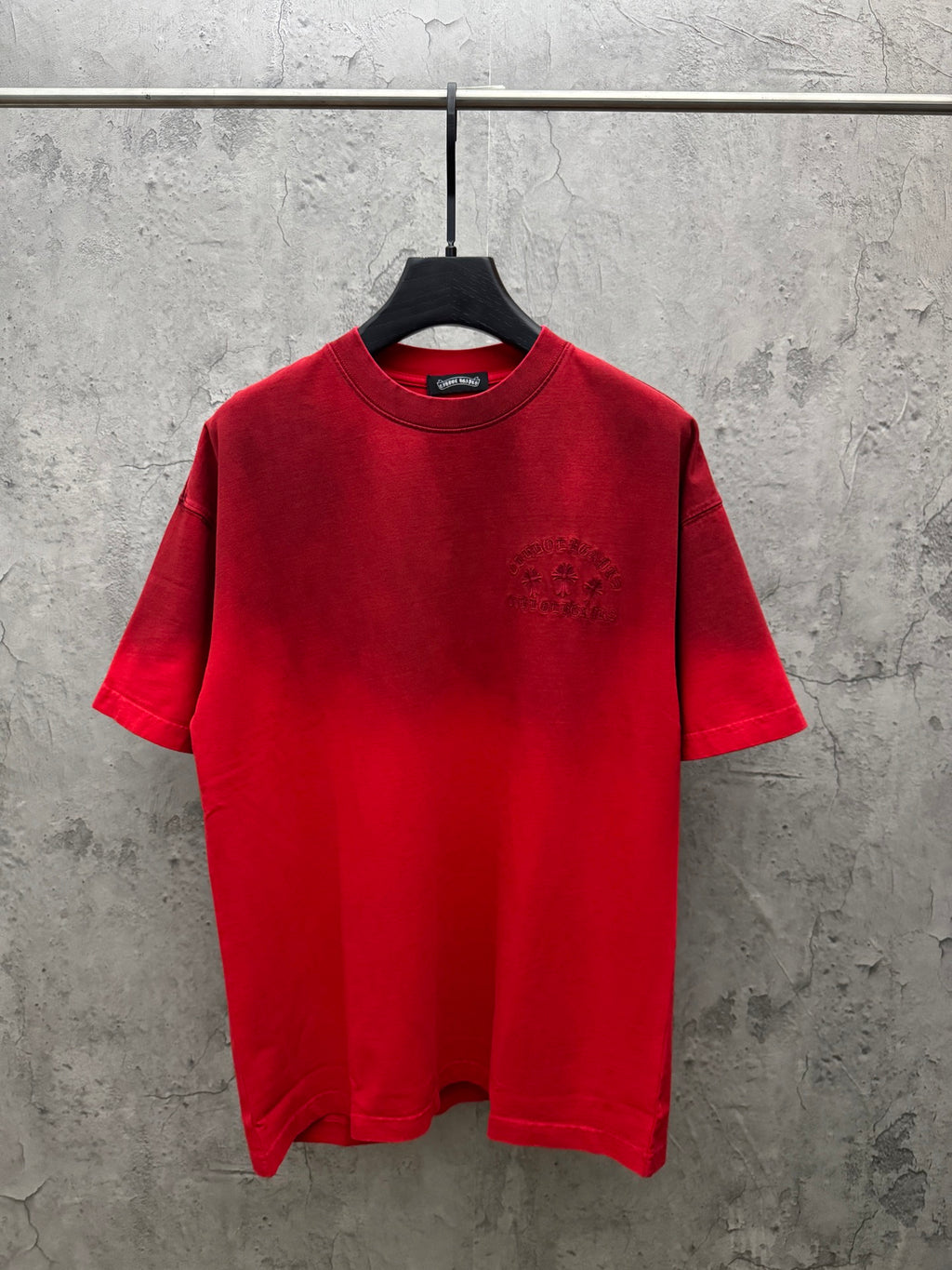 Red graphic T-shirt with crew neck, short sleeves, and small chest emblem