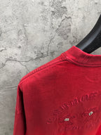 Red T-shirt back shoulder close-up with small rhinestone flowers and text logo