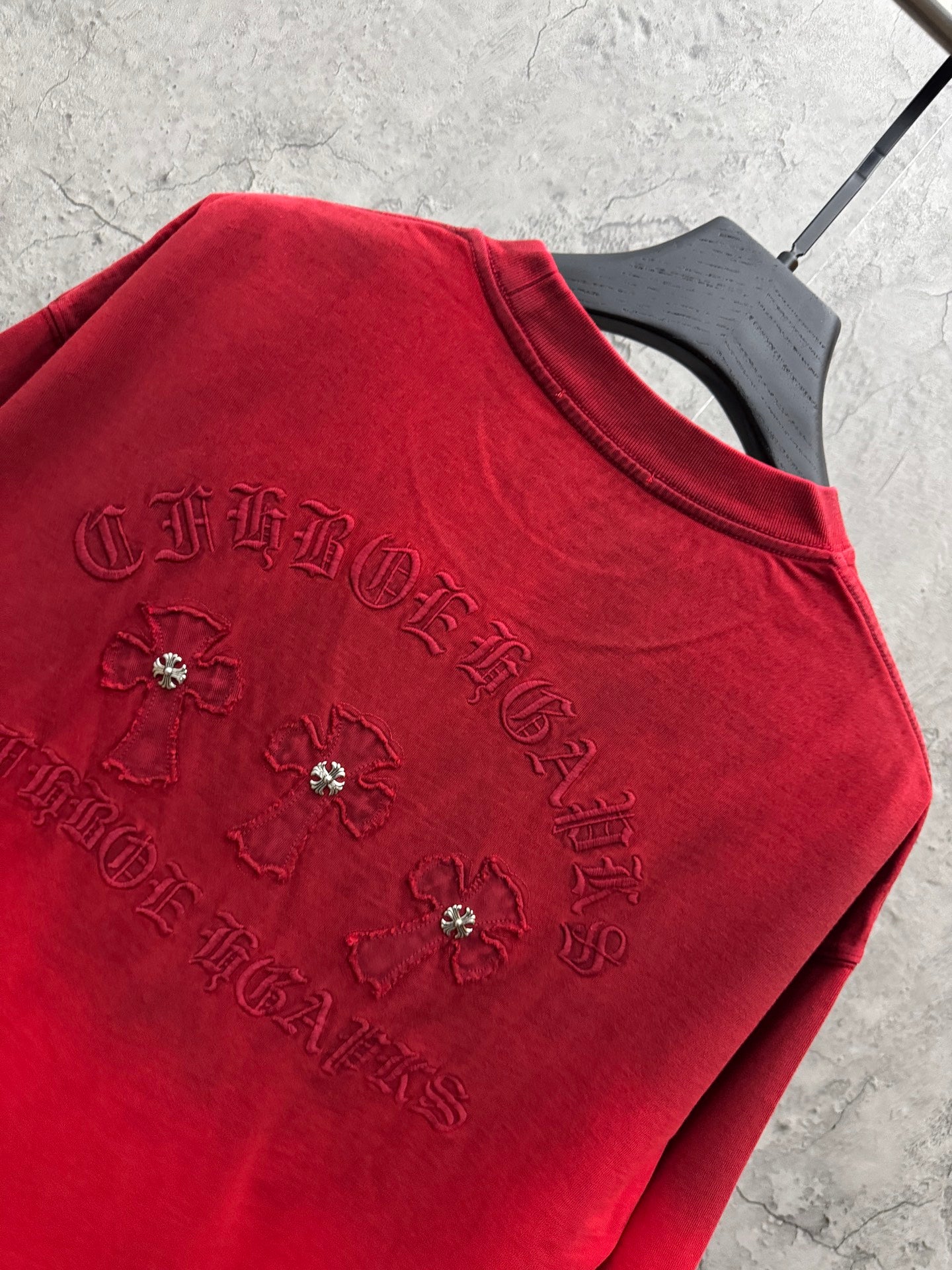 Red T-shirt close-up with embroidered flower motifs and jeweled embellishments