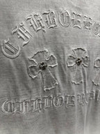 Light gray T-shirt back embroidery close-up with ornate lettering and cross motifs