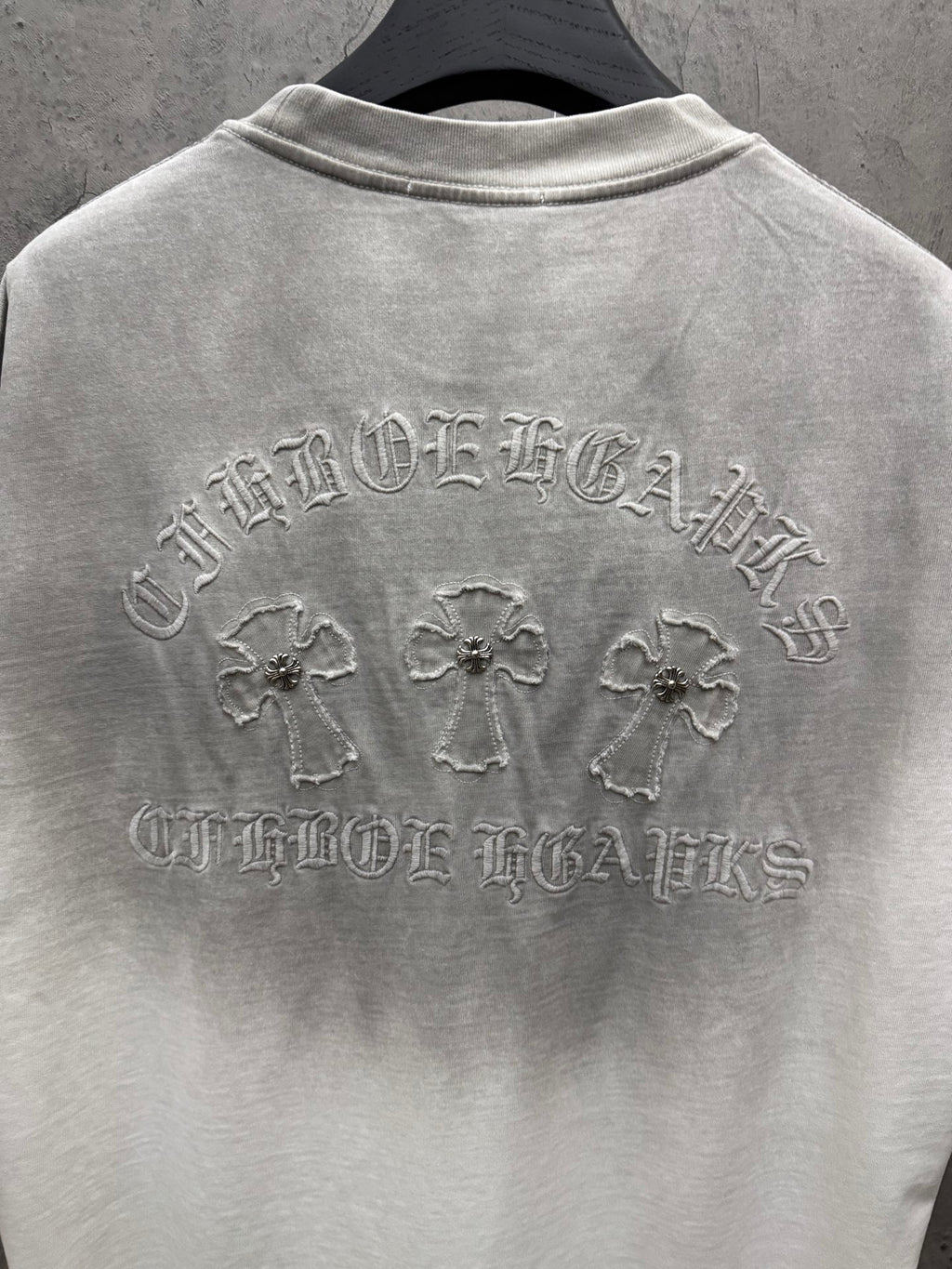 Light gray short-sleeve T-shirt back view with embroidered crest, crosses, and text