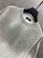 Light gray T-shirt close-up: crew neck and small centered chest embroidery detail