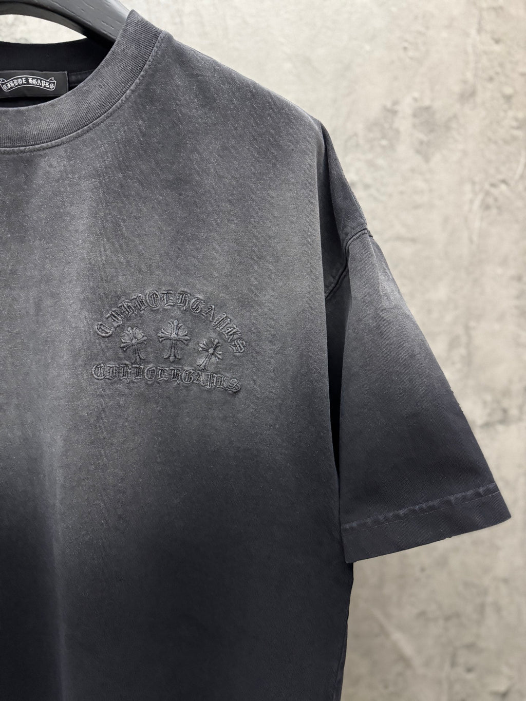 Dark gray T-shirt with small raised chest logo graphic