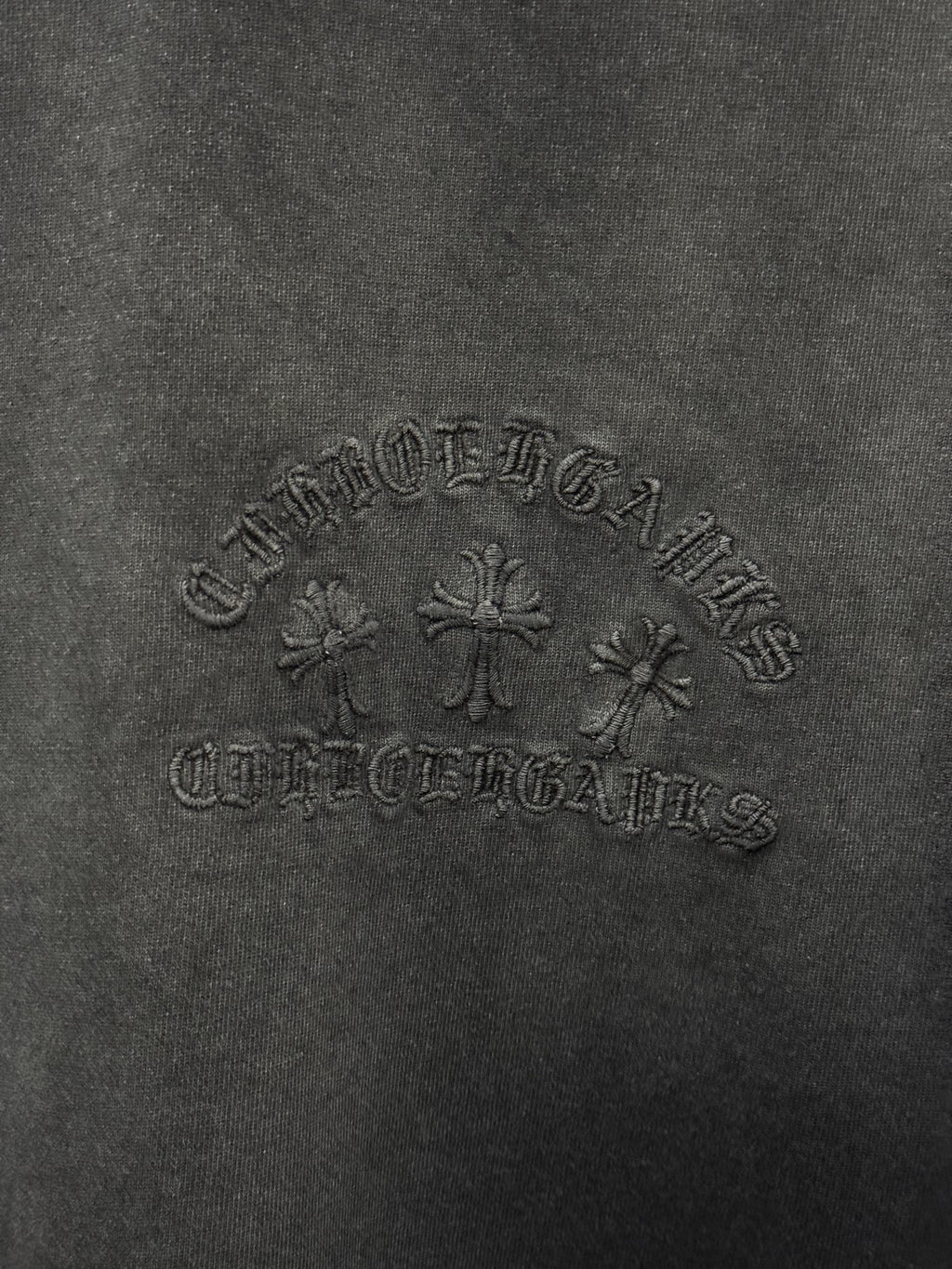 Dark gray fabric texture with raised central logo graphic