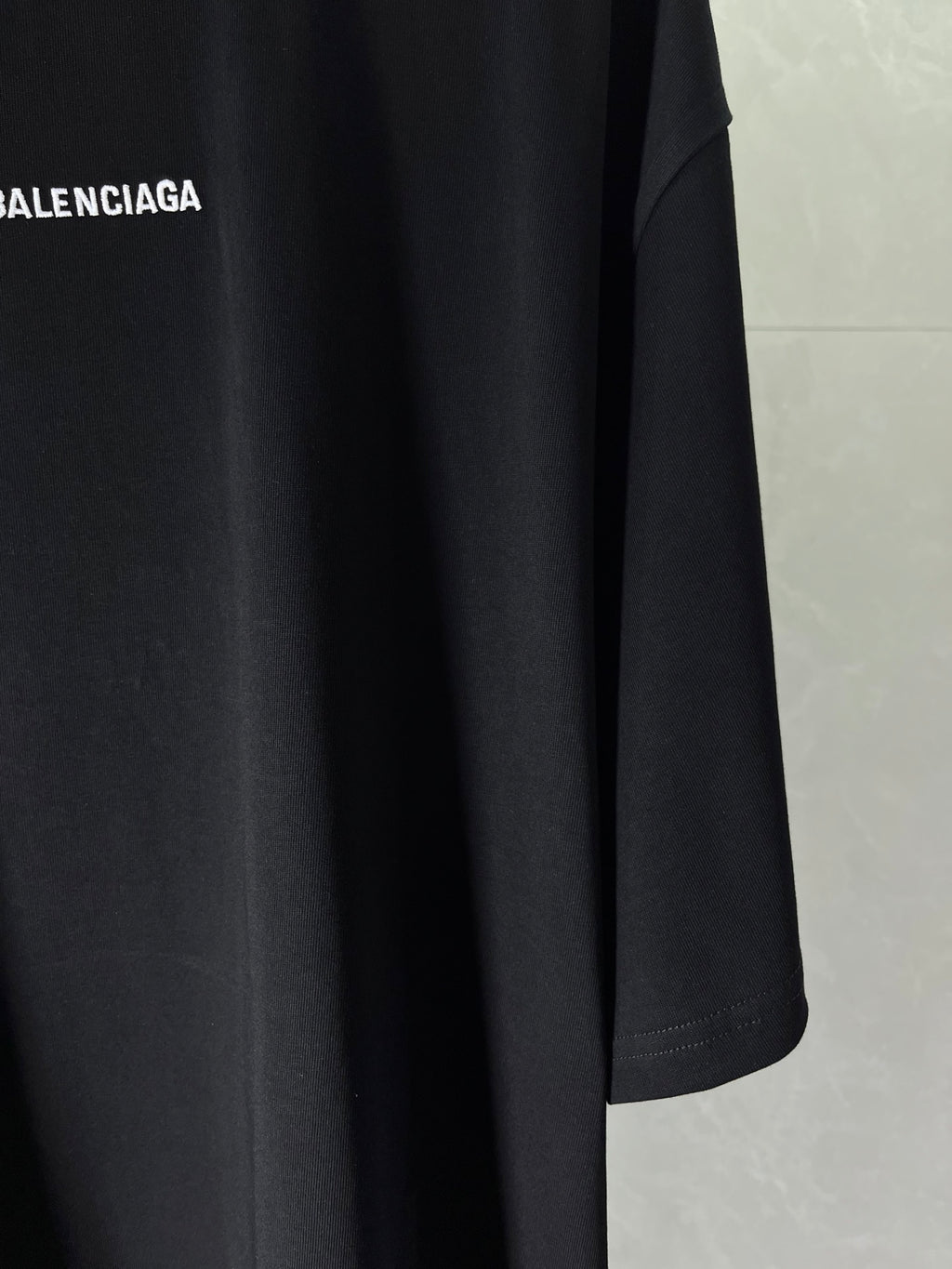Balenciaga dark navy T-shirt sleeve and hem detail, smooth fabric drape