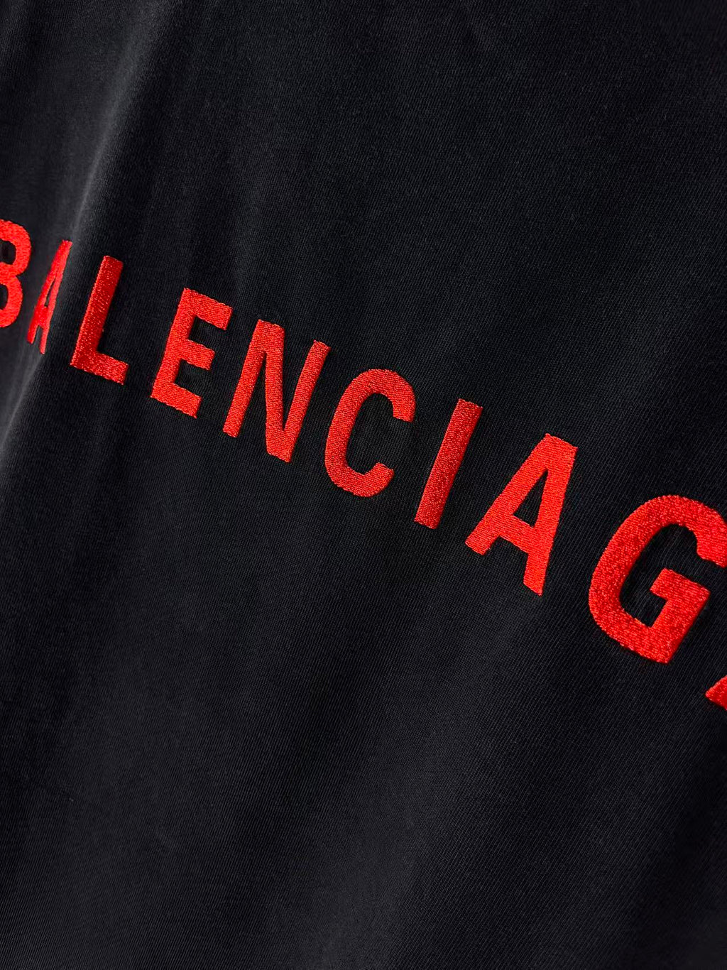 Balenciaga red BALENCIAGA lettering close-up on dark T-shirt