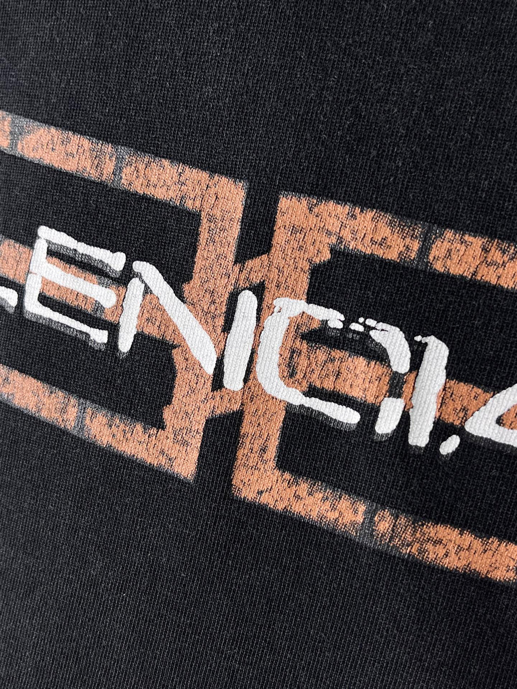 Balenciaga T-shirt, dark fabric, tight close-up of front logo graphic