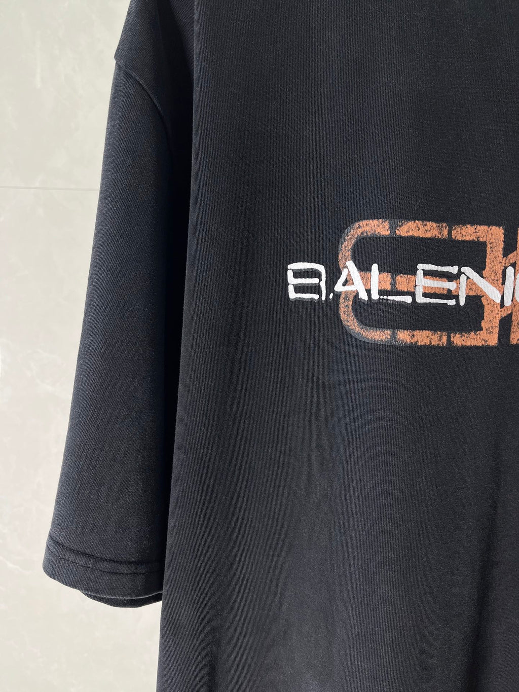 Balenciaga short-sleeve T-shirt, dark color, side view with partial logo print