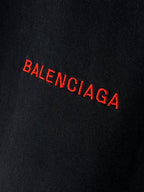 Balenciaga red BALENCIAGA logo close-up on dark fabric