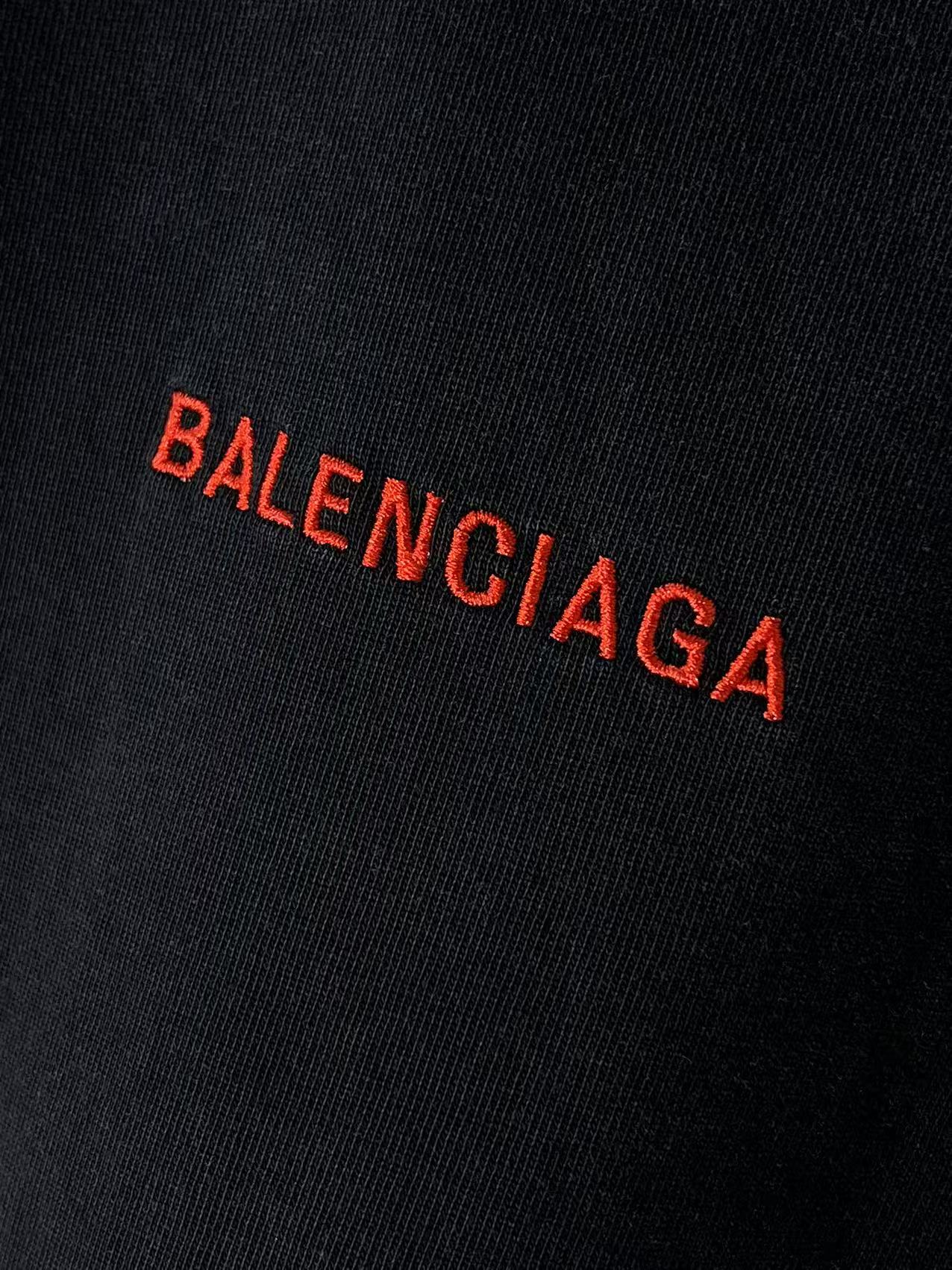 Balenciaga red BALENCIAGA logo close-up on dark fabric