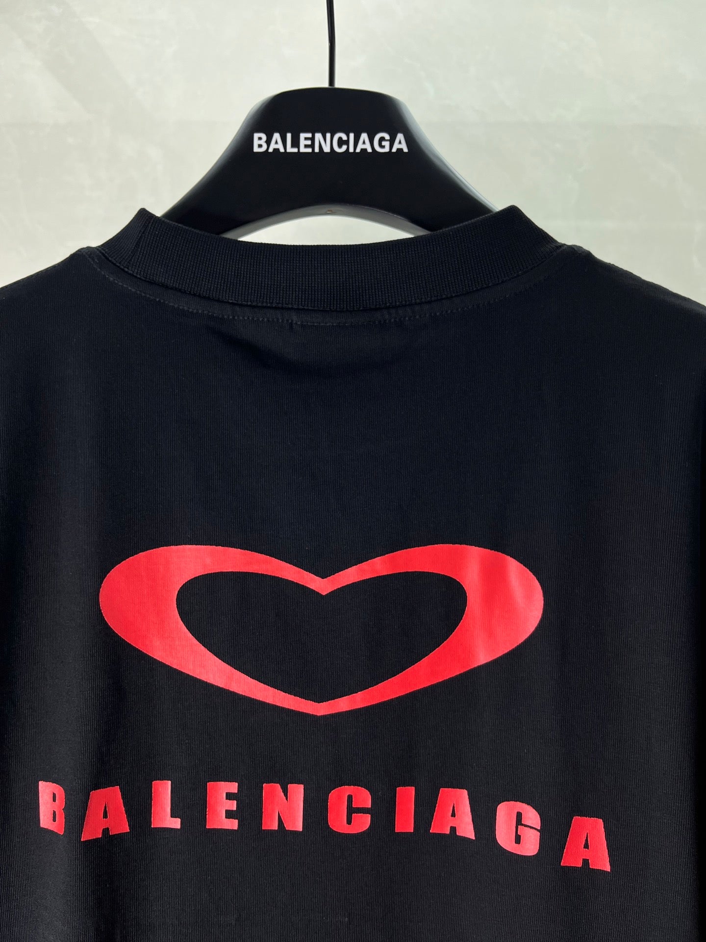 Black T-shirt with crew neck and large red heart logo, Balenciaga text below