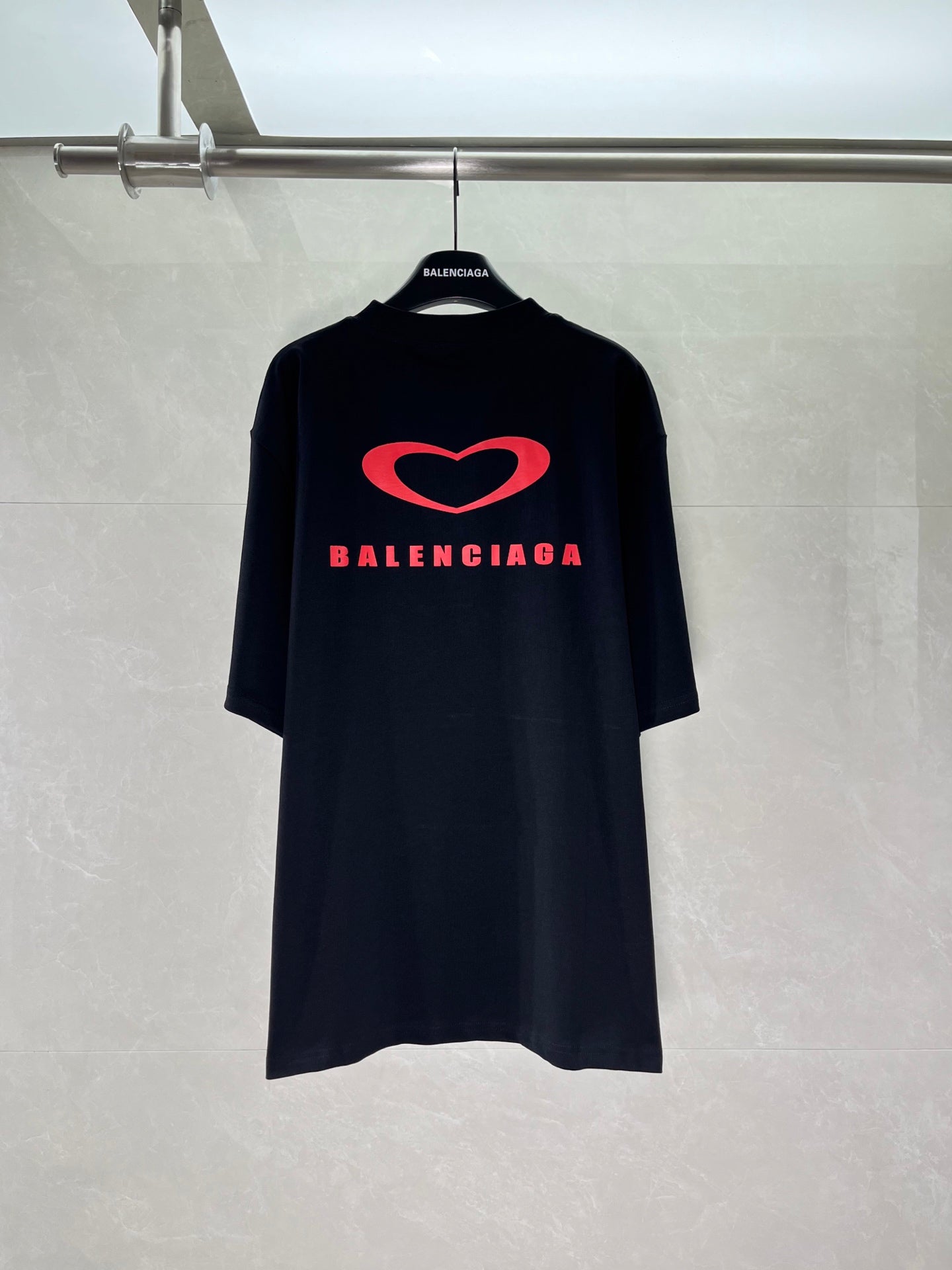 Black T-shirt with large red heart and Balenciaga logo across the chest