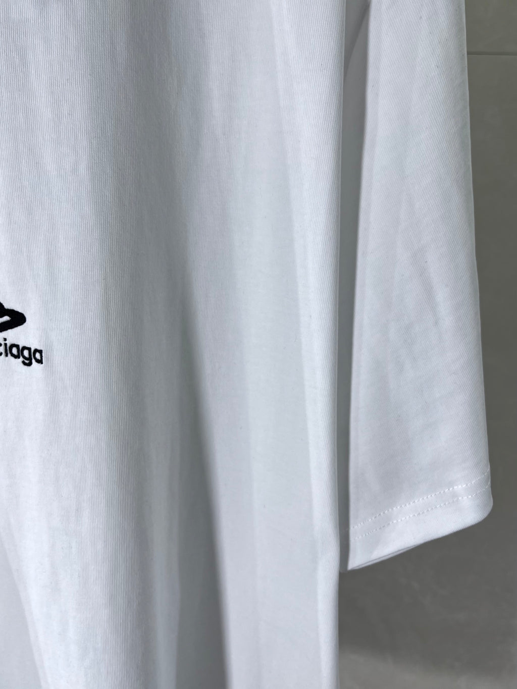 Balenciaga white T-shirt hem close-up with black logo