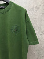 Green crew-neck T-shirt with small chest logo and short sleeves