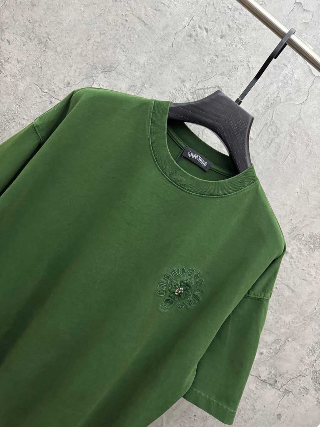 Green crew-neck T-shirt sleeve and chest logo embroidery detail