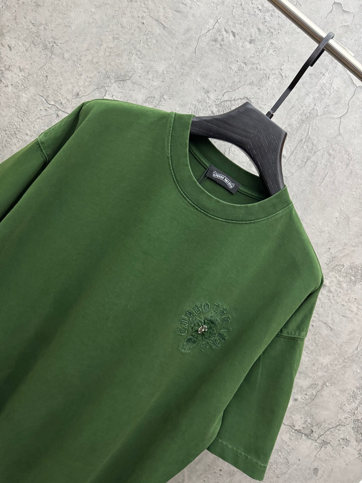 Green crew-neck T-shirt sleeve and chest logo embroidery detail