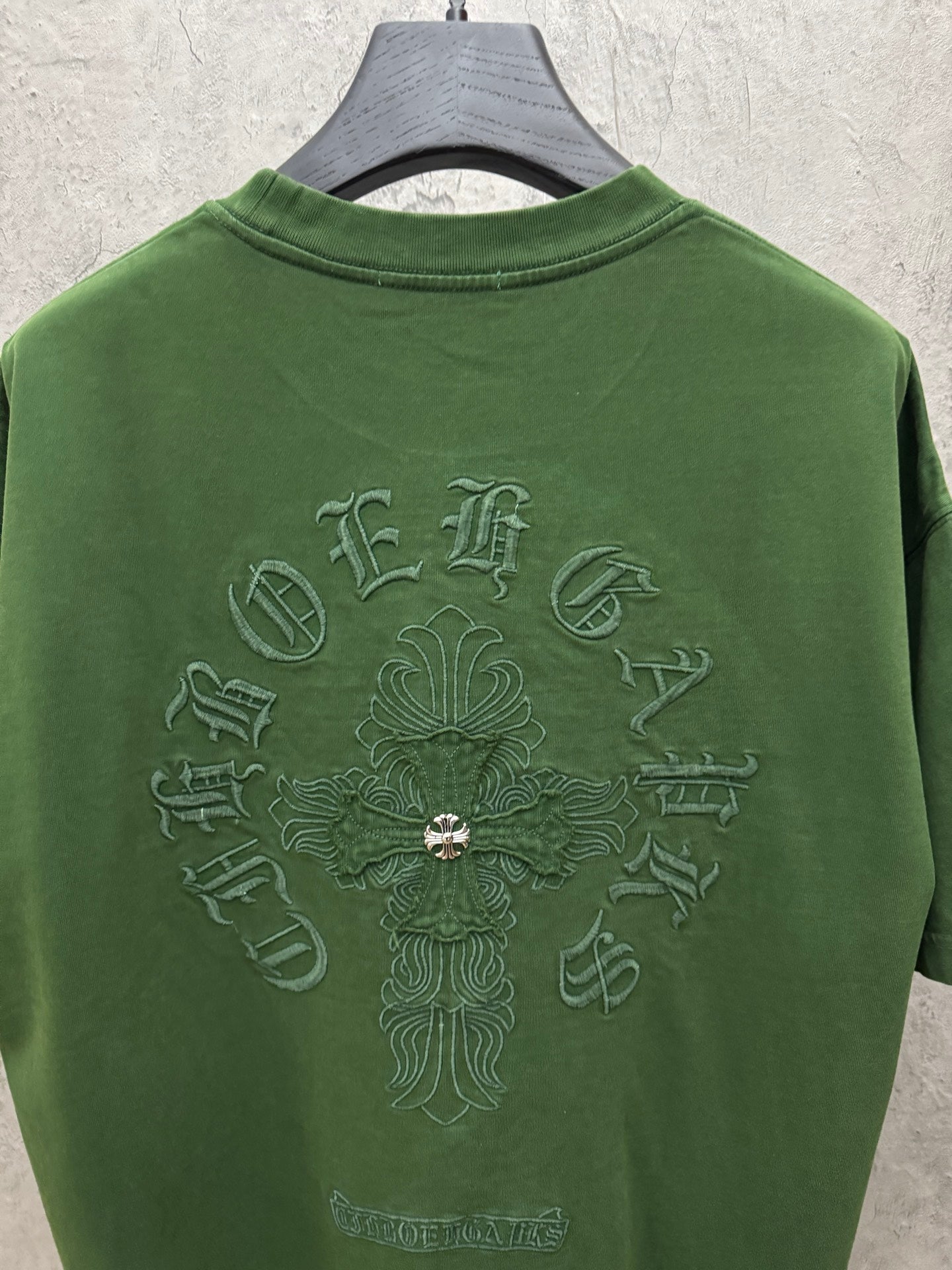 Green crew-neck T-shirt with large back graphic and central embroidered cross