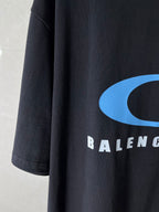 Balenciaga dark T-shirt sleeve/side with blue logo curve and partial BALENCIAGA