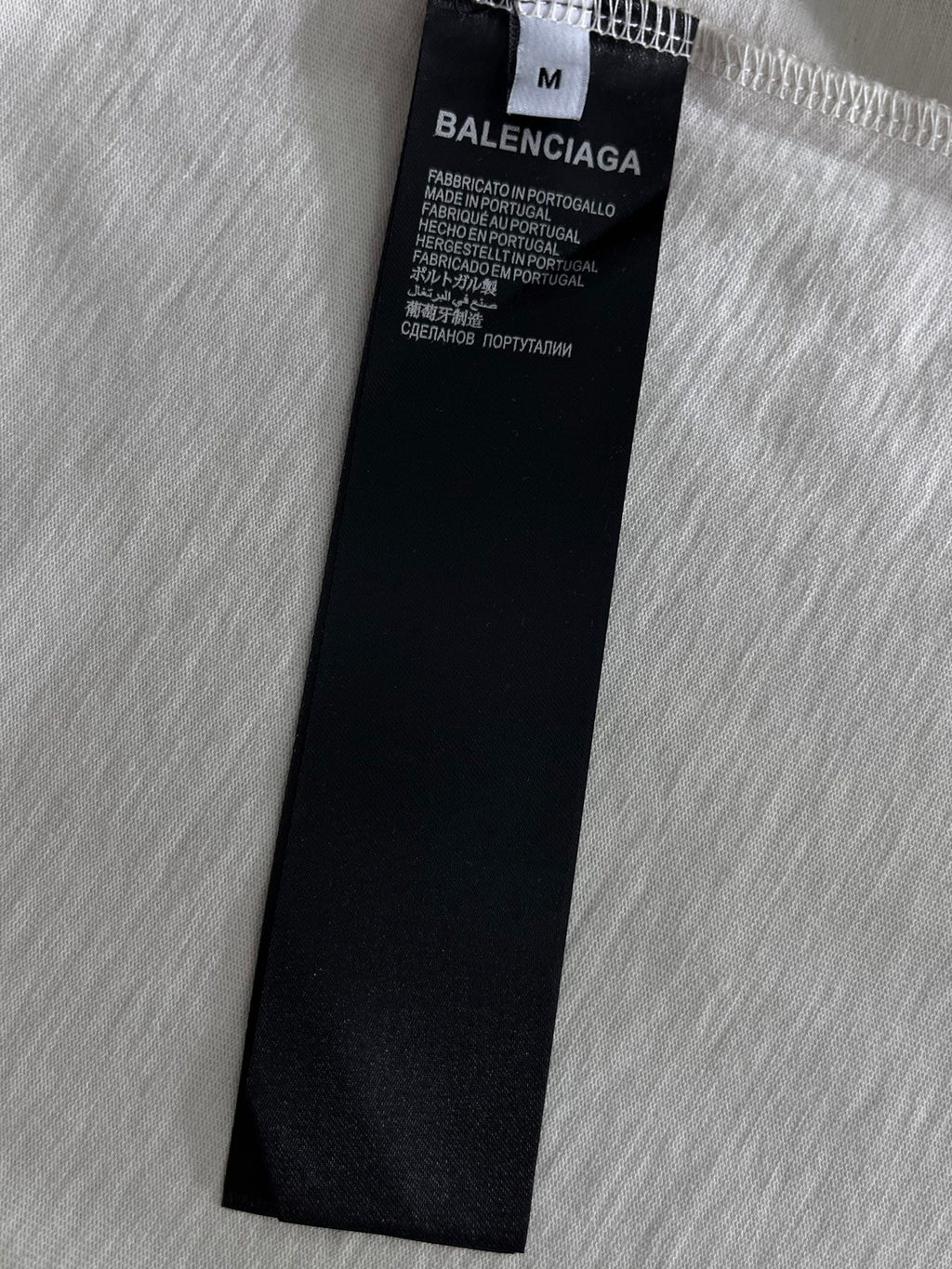 Black fabric care label on white T-shirt marked BALENCIAGA
