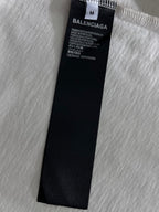 Black fabric care label on white T-shirt marked BALENCIAGA