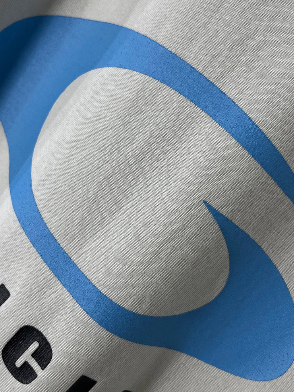 White T-shirt fabric with close-up of a blue curved BALENCIAGA logo