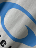 White T-shirt fabric with close-up of a blue curved BALENCIAGA logo