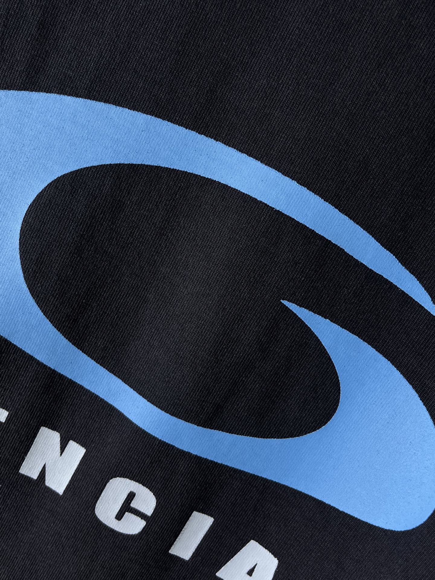 Balenciaga dark T-shirt fabric close-up with blue oval logo