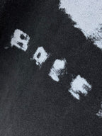 Balenciaga dark T-shirt close-up of white “RAVE” letters in graphic print