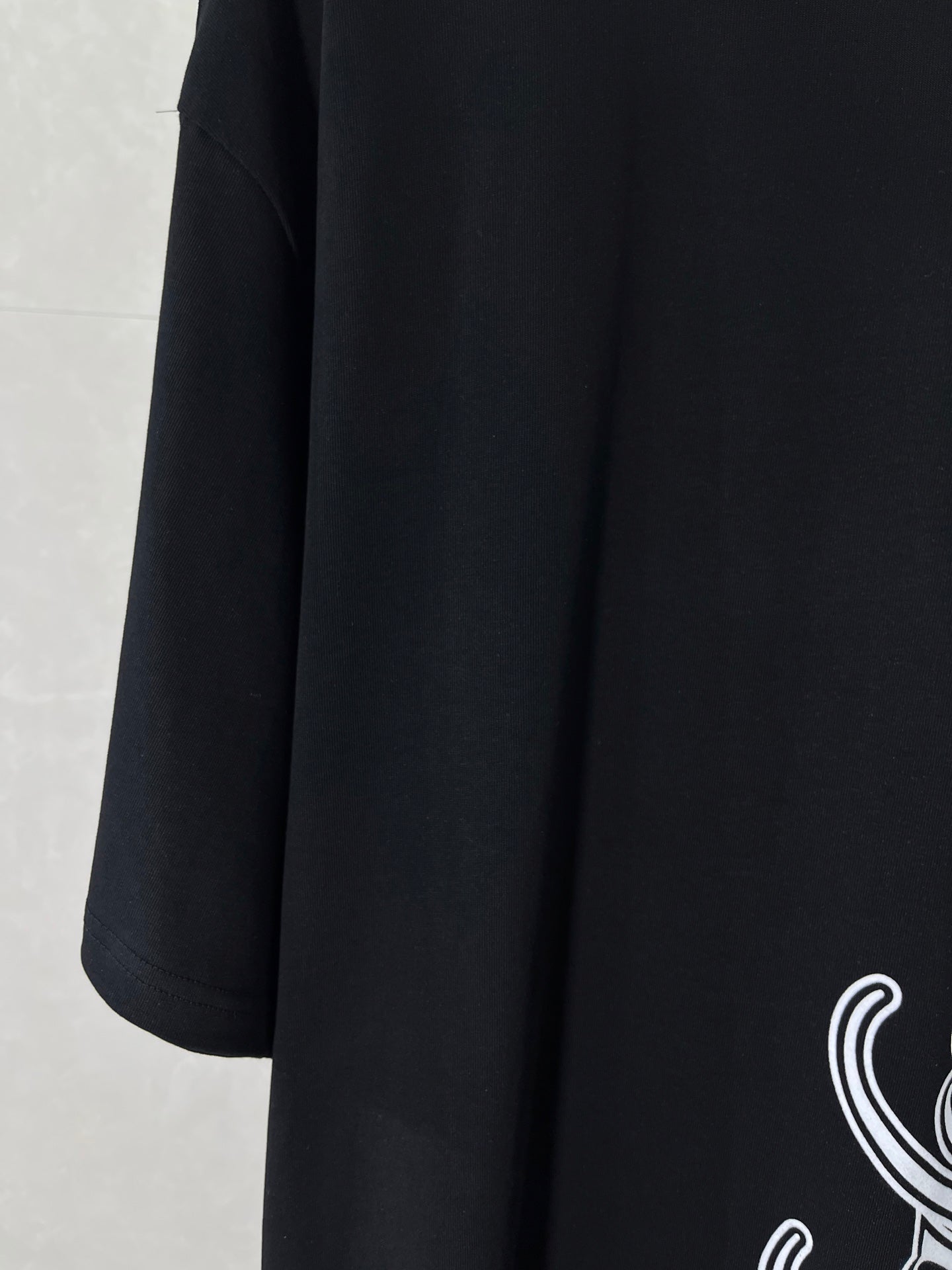 Balenciaga black T-shirt side view with partial white script logo print