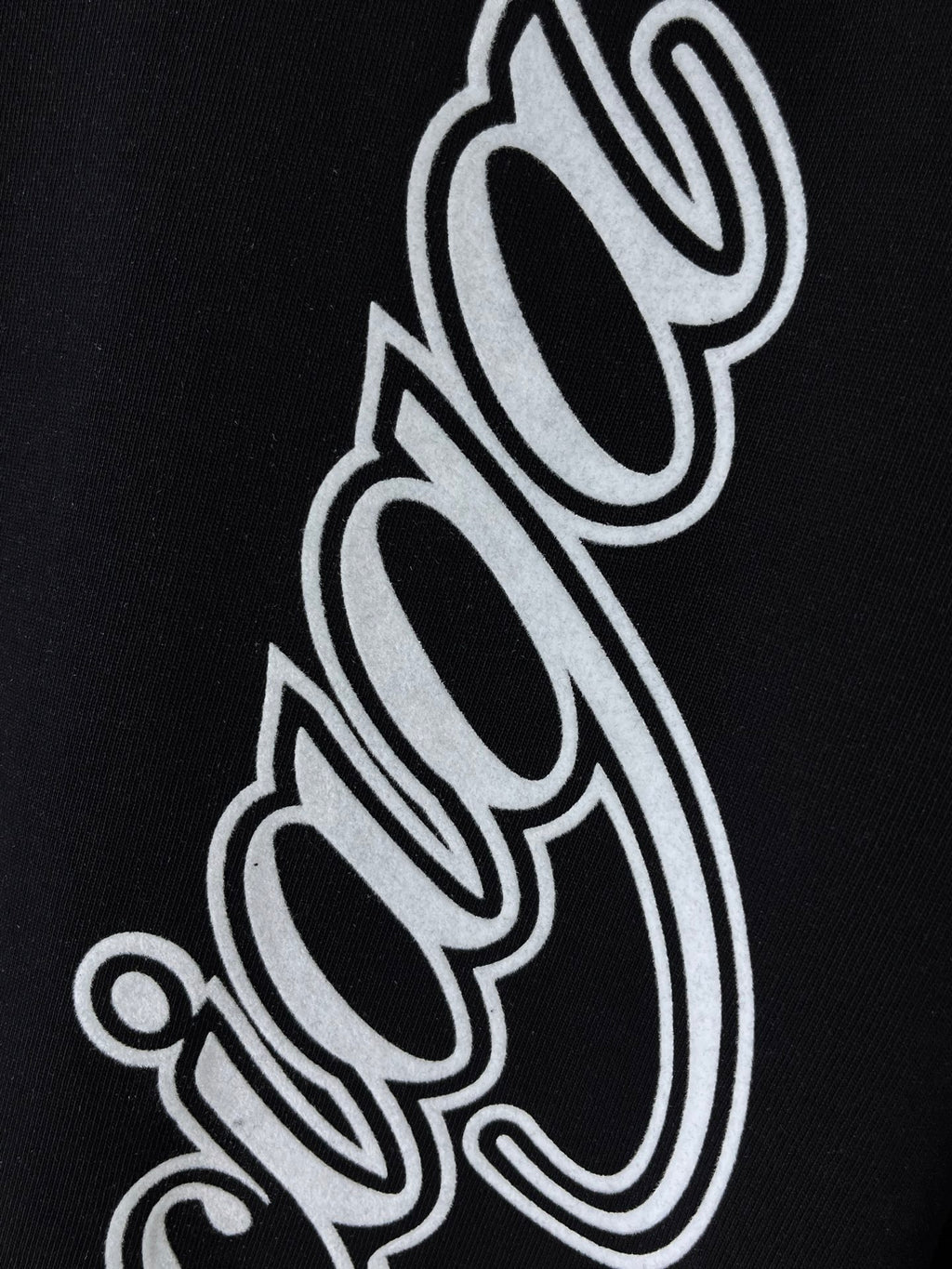 Balenciaga black T-shirt close-up of white outlined script letters