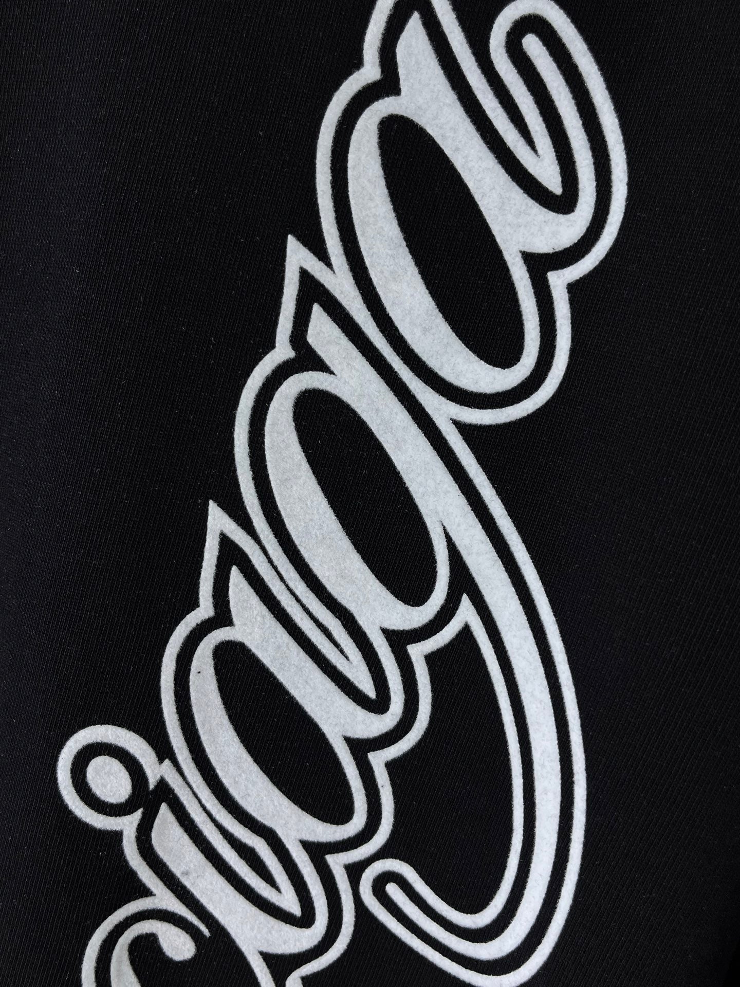 Balenciaga black T-shirt close-up of white outlined script letters