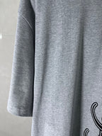 Heather gray T-shirt sleeve and side seam with partial black graphic print