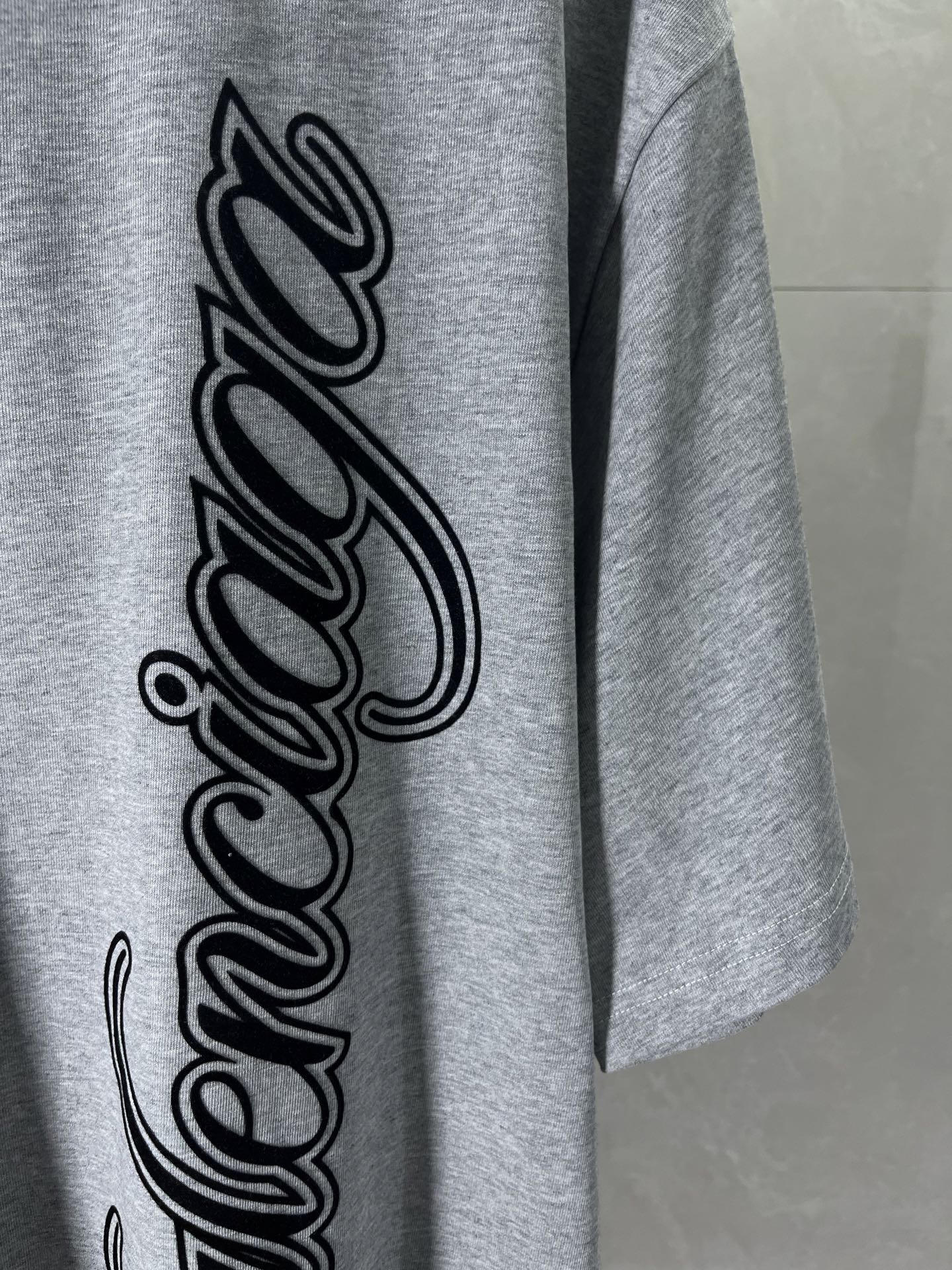 Heather gray T-shirt with large black cursive logo print on front