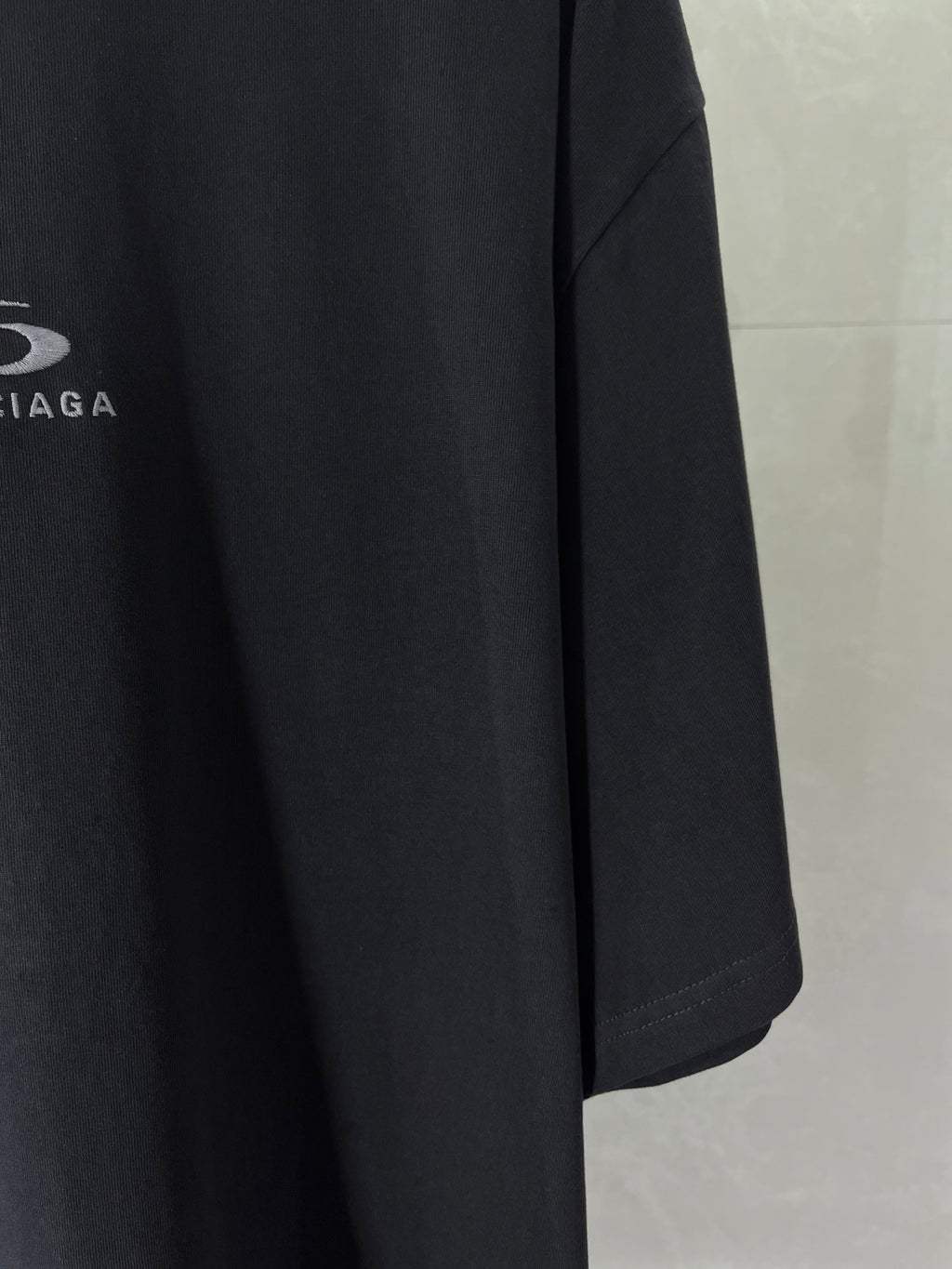 Navy T-shirt sleeve and side seam detail on crewneck shirt